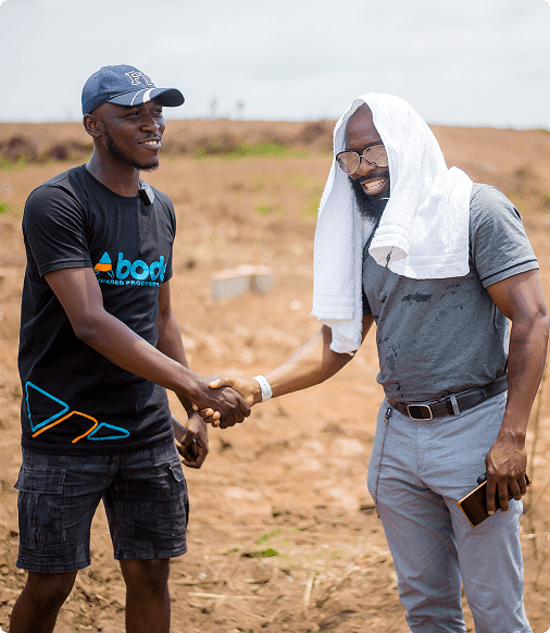 Two men shaking hands on a property site